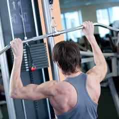 强大的肌肉发达的男人。提升权重健身房