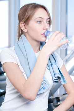 女人健身房锻炼运行机喝水