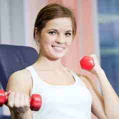 美丽的体育运动女人锻炼哑铃重量