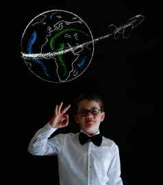 男孩穿着业务男人。粉笔全球飞机世界旅行黑板上背景