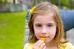 金发碧眼的孩子女孩吃玉米零食户外公园
