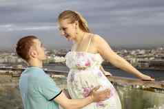 年轻的夫妇期待婴儿年轻的怀孕了女人走屋顶丈夫