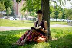 美丽的赶时髦的人短头发女人阅读书公园