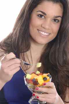 模型发布年轻的女人吃新鲜的水果沙拉