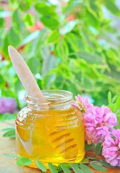 玻璃Jar完整的蜂蜜坚持金合欢粉红色的白色弗洛