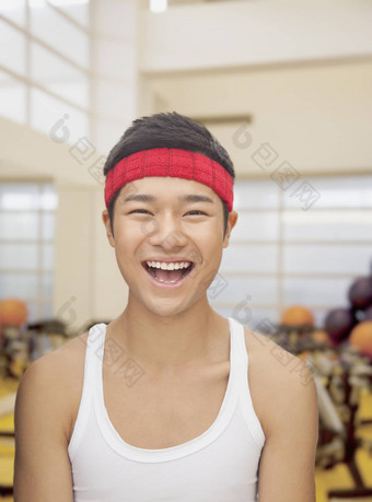 肖像微笑年轻的男人。健身房