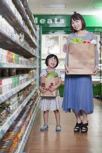 妈妈。女儿持有杂货店袋超市北京