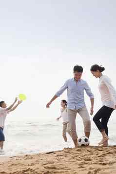 年轻的人玩足球飞盘海滩中国