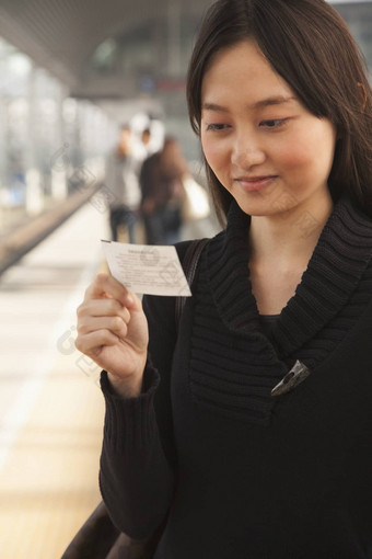 年轻的女人火车票铁路平台