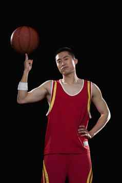 篮球球员旋转球手指黑色的背景