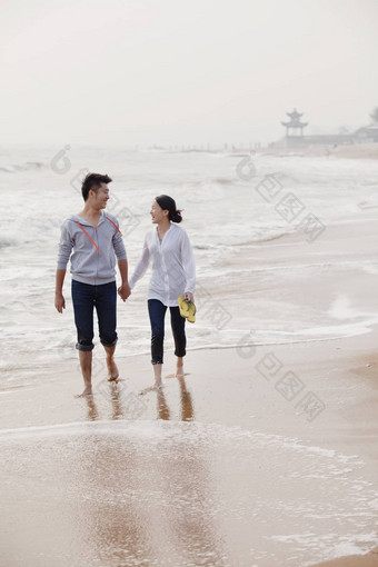 年轻的夫妇走水域<strong>边缘</strong>海滩中国