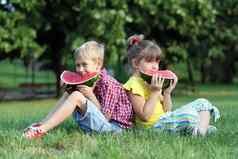 男孩女孩坐着草吃西瓜