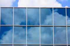 蓝色的天空反映了现代建筑镜子玻璃墙