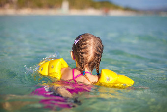 可爱的女孩游泳海热带海滩假期