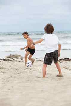 快乐家庭父亲孩子们玩足球海滩夏天