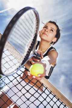 美丽的年轻的女孩休息网球网