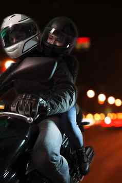 年轻的夫妇骑摩托车城市街道晚上北京