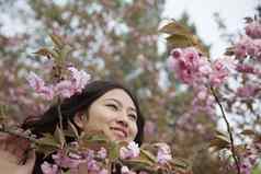 肖像微笑宁静年轻的女人美丽的粉红色的花朵公园春天