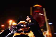 美丽的年轻的女人骑摩托车太阳镜城市街道晚上
