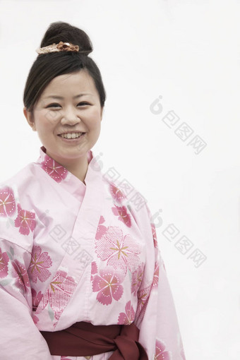 肖像年轻的微笑女人粉红色的日本和服工作室拍摄