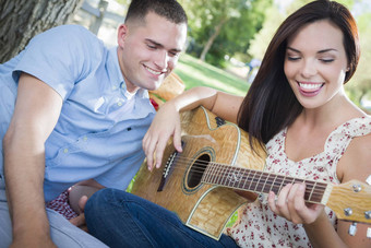 混合比赛夫妇公园玩吉他唱歌