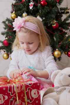 女孩粉红色的圣诞节树持有礼品盒
