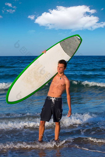 男孩青少年冲浪者持有冲浪板海滩