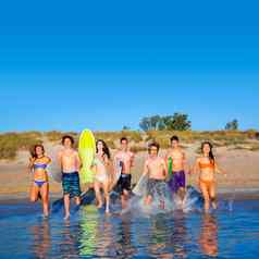 青少年冲浪者集团运行海滩溅