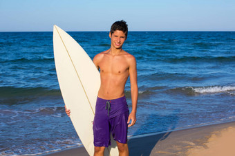 男孩青少年冲浪者快乐钻冲浪板海滩
