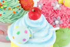 色彩斑斓的甜蜜的纸杯蛋糕甜点食物背景