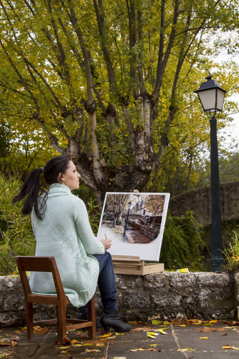 年轻的女人绘画公园