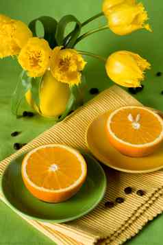 黄色的壶黄色的郁金香多汁的橙子早餐