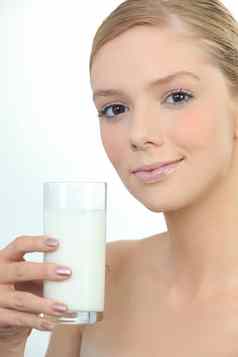 女人持有玻璃新鲜的牛奶