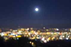 完整的月亮上升模糊城市灯景观