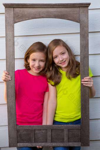 双胞胎妹妹女孩摆姿势岁的木边境框架