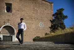 年轻的男人。走楼梯前面教堂罗马意大利