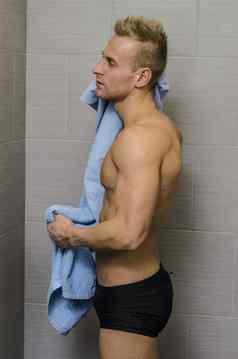 英俊的半裸年轻的男人。浴室毛巾