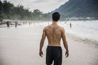 回来年轻的男人。站边缘海洋