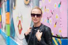 女人会说话的智能手机倾斜色彩斑斓的涂鸦墙纽约城市美国