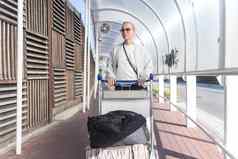 年轻的女人运输行李到来停车国际机场离开termainal行李电车