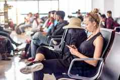 女旅行者会说话的细胞电话等待董事会飞机离开盖茨亚洲机场终端