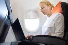 有吸引力的高加索人女乘客工作现代移动PC电脑无线连接董事会商业飞机飞行