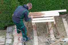 男人。中风保护油漆木花园家具