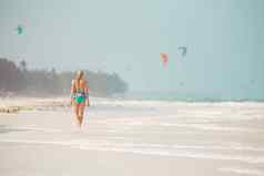 快乐女人有趣的享受夏天走快乐热带海滩桑给巴尔坦桑尼亚