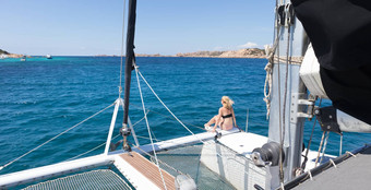女人放松夏天航行巡航坐着奢侈品双体船图片完美的白色桑迪海滩斯帕吉岛马达莱娜群岛撒丁岛意大利