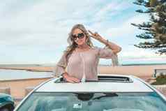 有趣的无忧无虑的女人享受旅行旅行海滩车