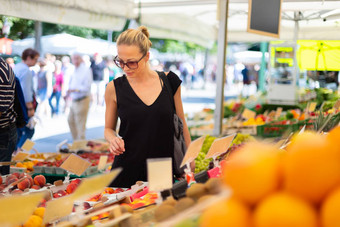 女人购买水果蔬菜当地的食物市场市场摊位各种有机蔬菜