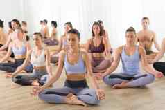 集团年轻的运动有吸引力的人瑜伽工作室练习瑜伽教训教练坐着地板上siddhasana容易坐着瑜伽构成健康的活跃的生活方式工作健身房
