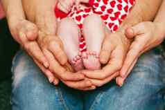 脚新生儿婴儿手父母快乐家庭概念妈妈爸爸拥抱婴儿的腿