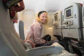 放松快乐的运动休闲年轻的金发女郎高加索人女人微笑相机enjoing额外的空间旅行经济类商业飞机